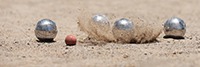 Boulekugeln und spritzender Sand